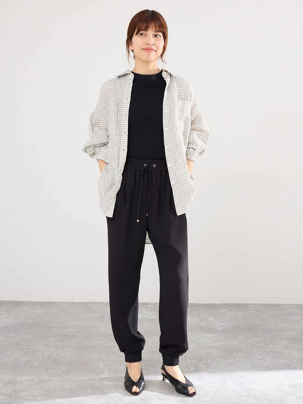 ブラック系のスウェットパンツ、ベージュ系のシャツ/ブラウスを着用したレディースの春コーディネートの1枚目の写真