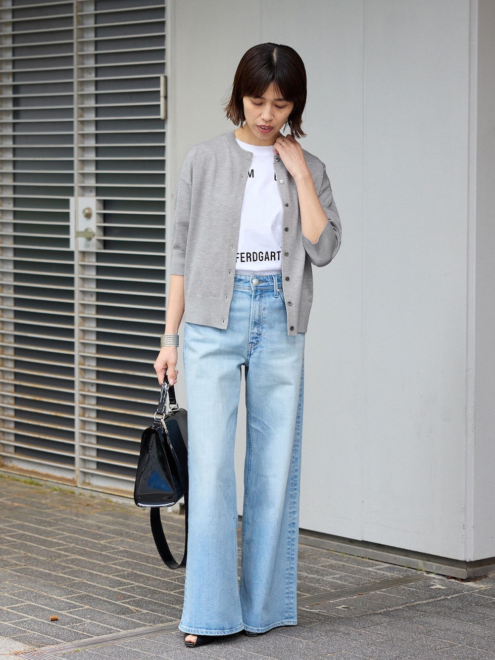 ブルー系のデニムパンツ、ホワイト系のTシャツ/カットソー、グレー系のカーディガン/ボレロを着用したレディースの春コーディネートの1枚目の写真