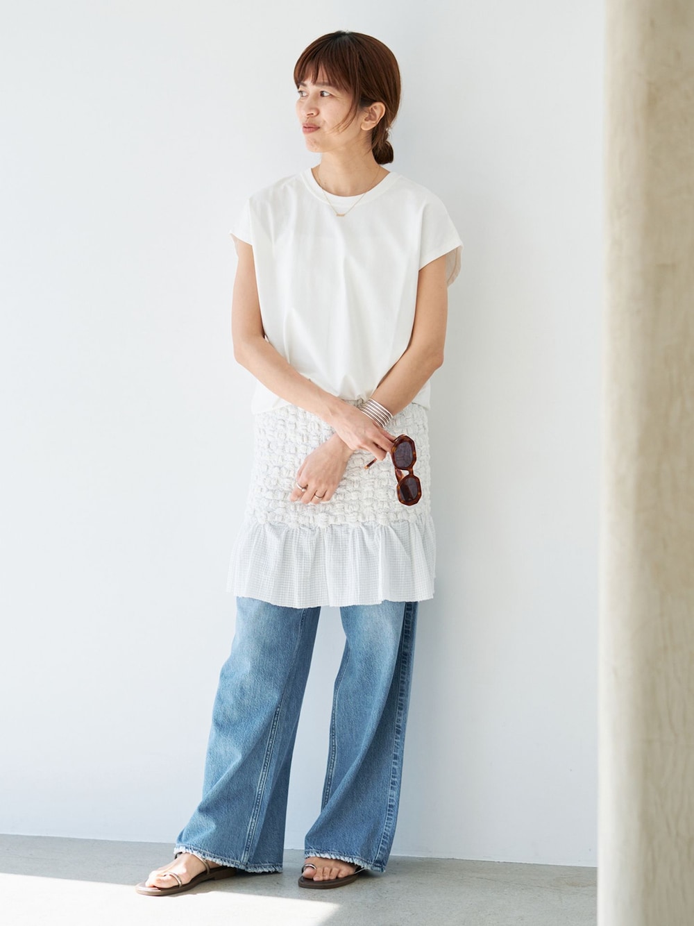 ホワイト系のスカート、ホワイト系のTシャツ/カットソー、ブラウン系のサンダルを着用したレディースの春コーディネートの1枚目の写真