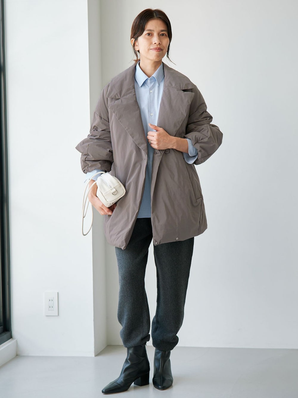 グレー系のダウンジャケット/コート、グレー系のその他パンツ、ブルー系のシャツ/ブラウスを着用したレディースの夏コーディネートの1枚目の写真