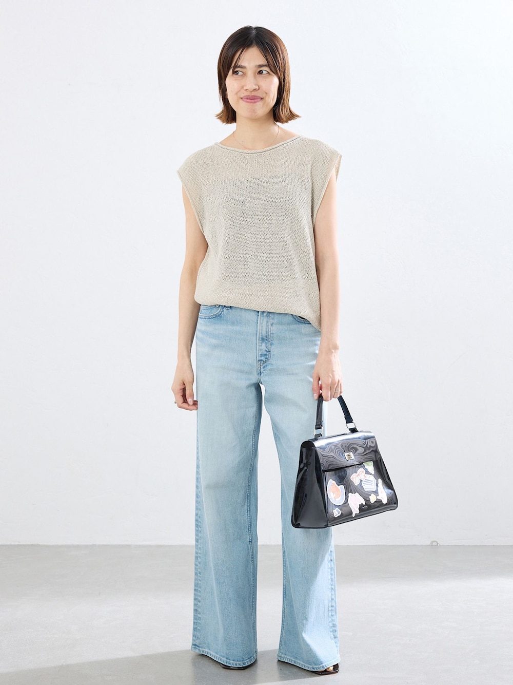 ブルー系のデニムパンツ、ベージュ系のニット/セーターを着用したレディースの春コーディネートの1枚目の写真