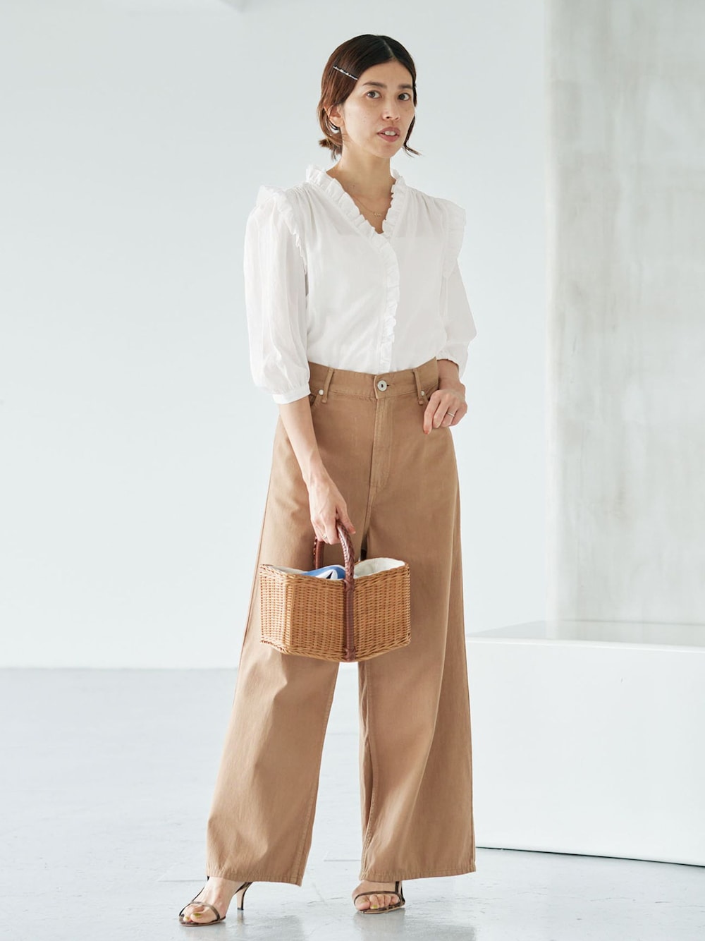 イエロー系のチノパンツ、ホワイト系のシャツ/ブラウス、イエロー系のハンドバッグを着用したレディースの夏コーディネートの1枚目の写真