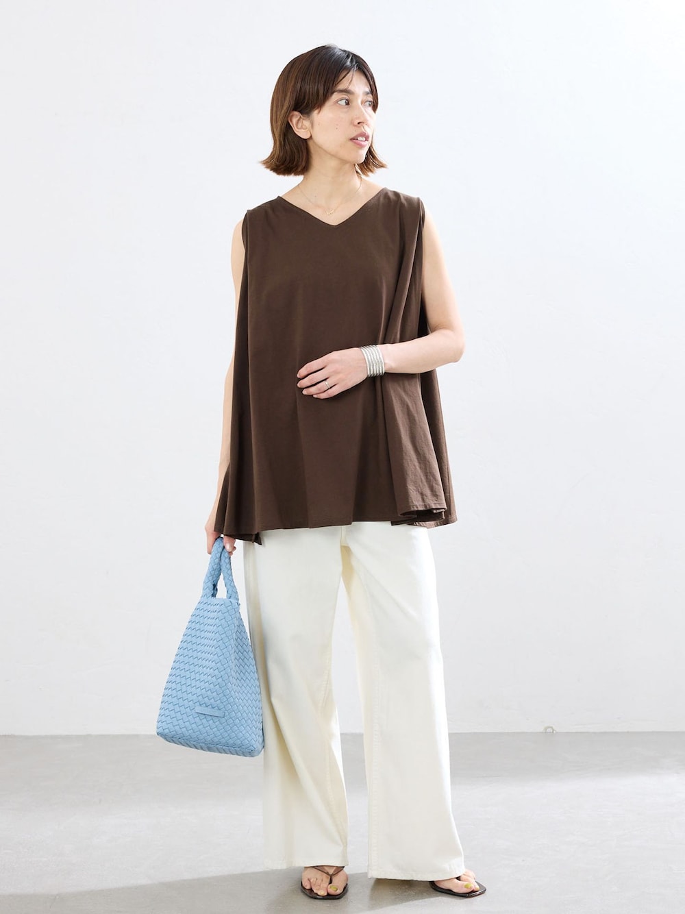 ブラウン系のTシャツ/カットソー、ブルー系のトートバッグを着用したレディースの春コーディネートの1枚目の写真