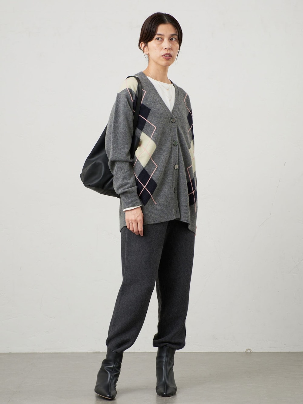 グレー系のその他パンツ、グレー系のカーディガン/ボレロ、ブラック系のブーツを着用したレディースの秋コーディネートの1枚目の写真