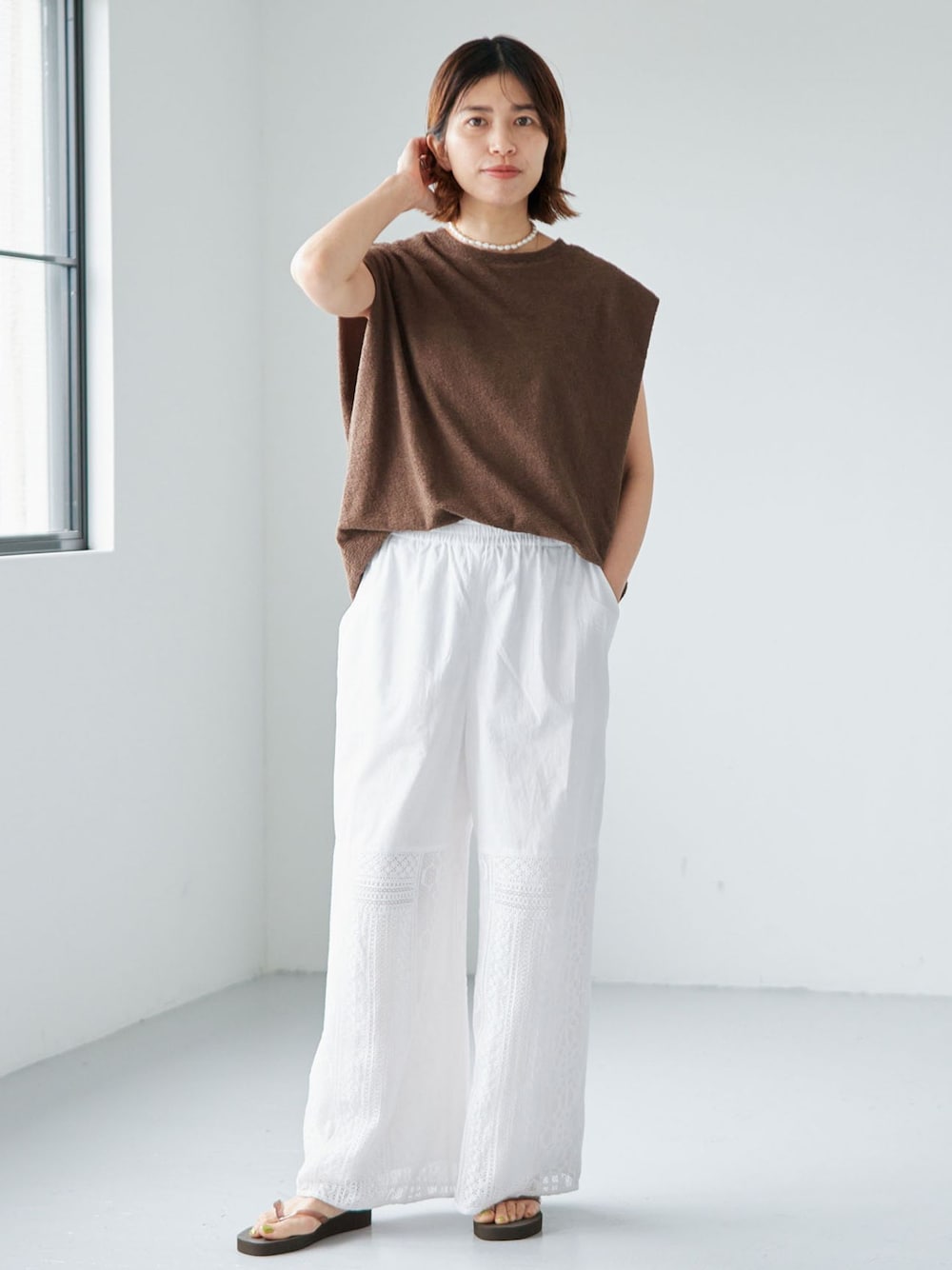 ホワイト系のその他パンツ、グリーン系のTシャツ/カットソー、ブラウン系のサンダルを着用したレディースの夏コーディネートの1枚目の写真