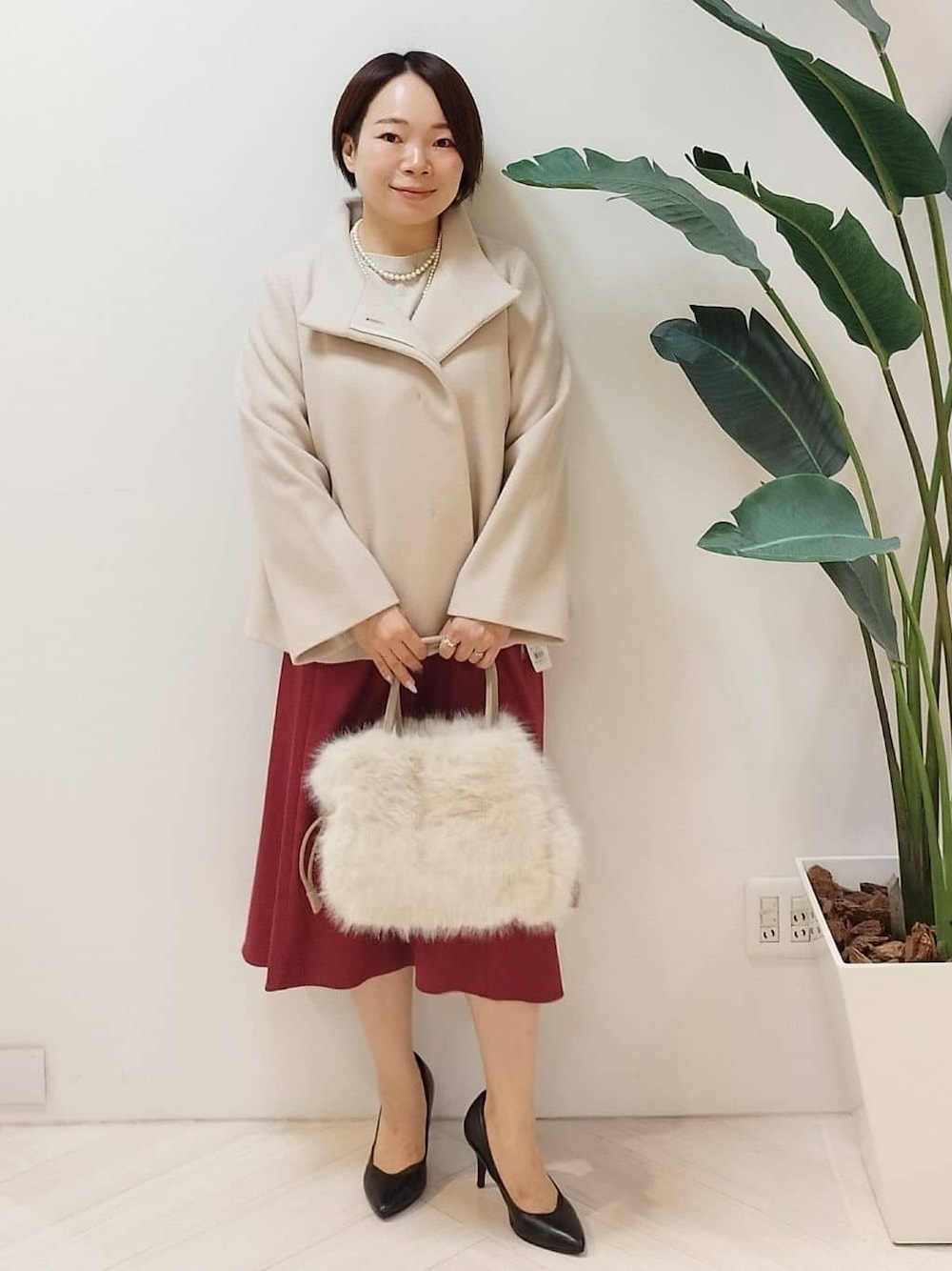 ベージュ系のその他アウター、ベージュ系のニット/セーター、レッド系のスカートを着用したレディースの冬コーディネートの1枚目の写真