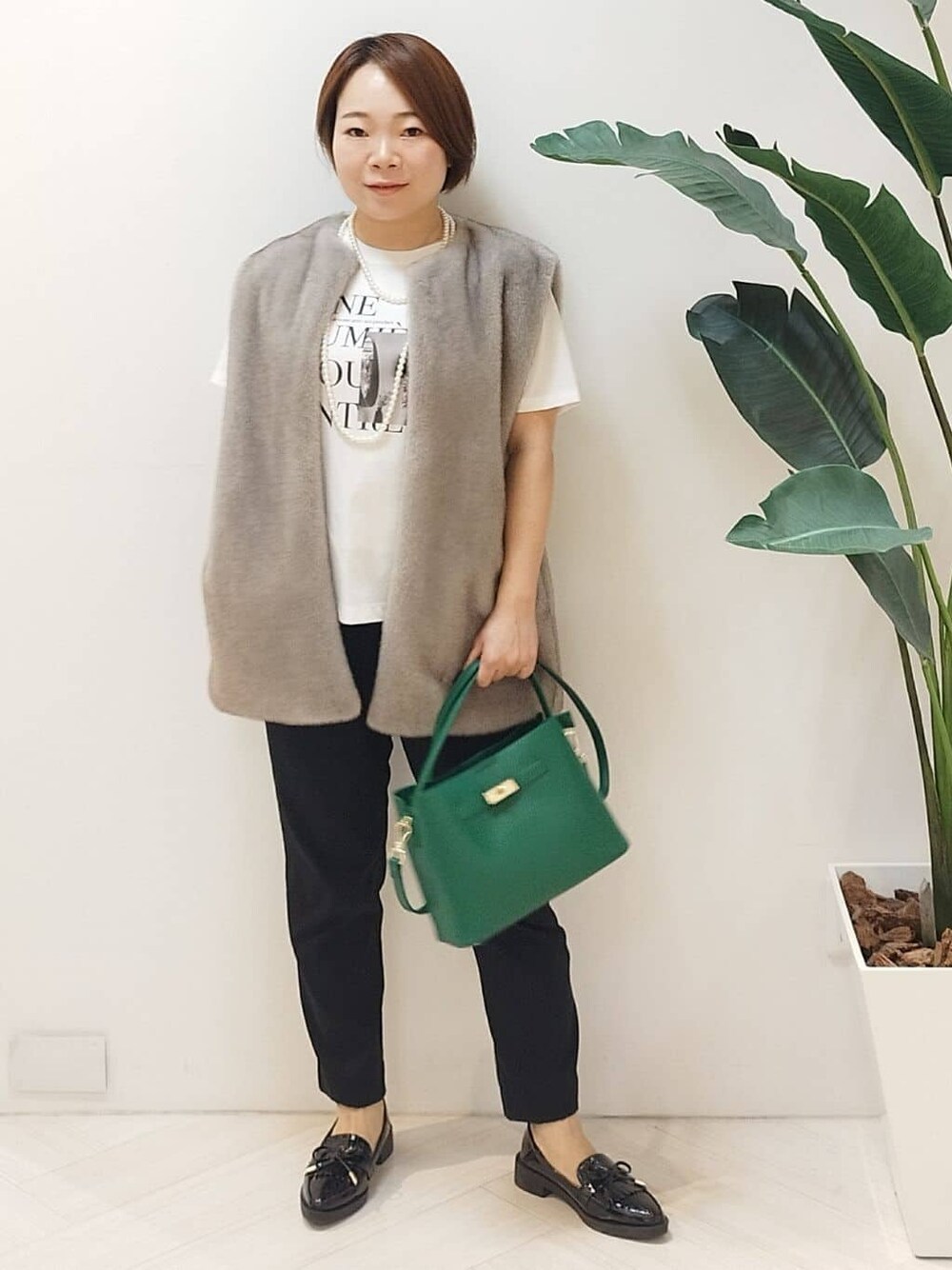 ベージュ系のベスト、ホワイト系のTシャツ/カットソー、ブラック系のその他パンツを着用したレディースの秋コーディネートの1枚目の写真