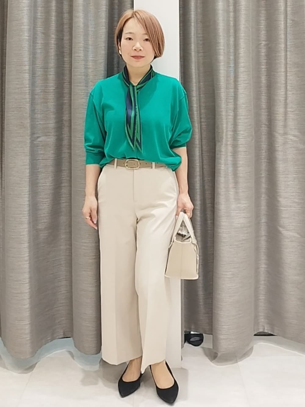 ベージュ系のその他パンツ、ベージュ系のトートバッグ、グリーン系のカーディガン/ボレロを着用したレディースの春コーディネートの1枚目の写真