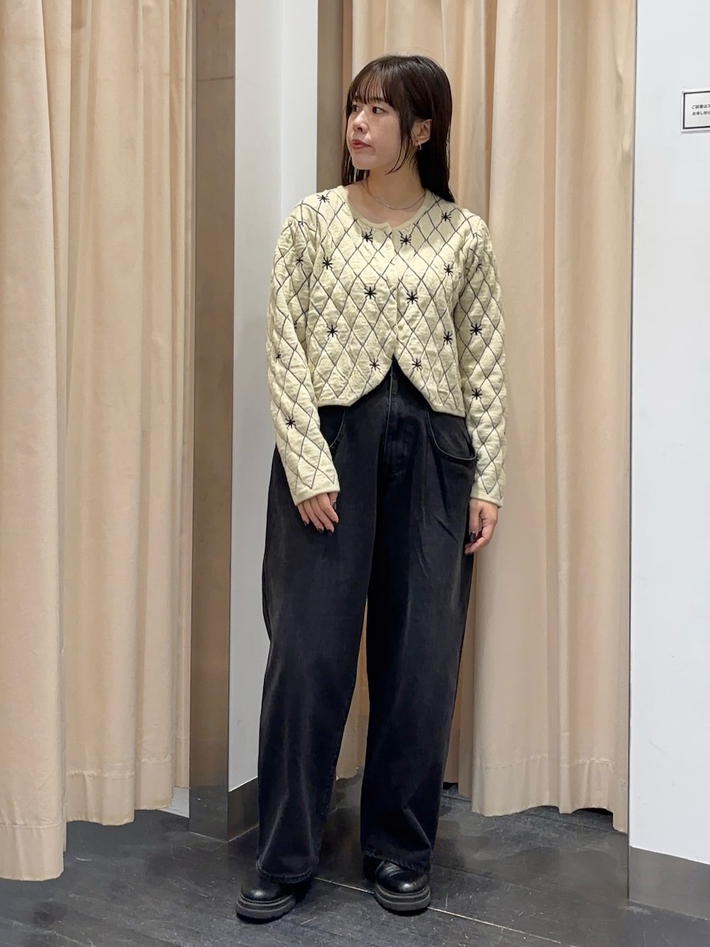 ベージュ系のニット/セーター、ブラック系のデニムパンツを着用したレディースの秋コーディネートの1枚目の写真