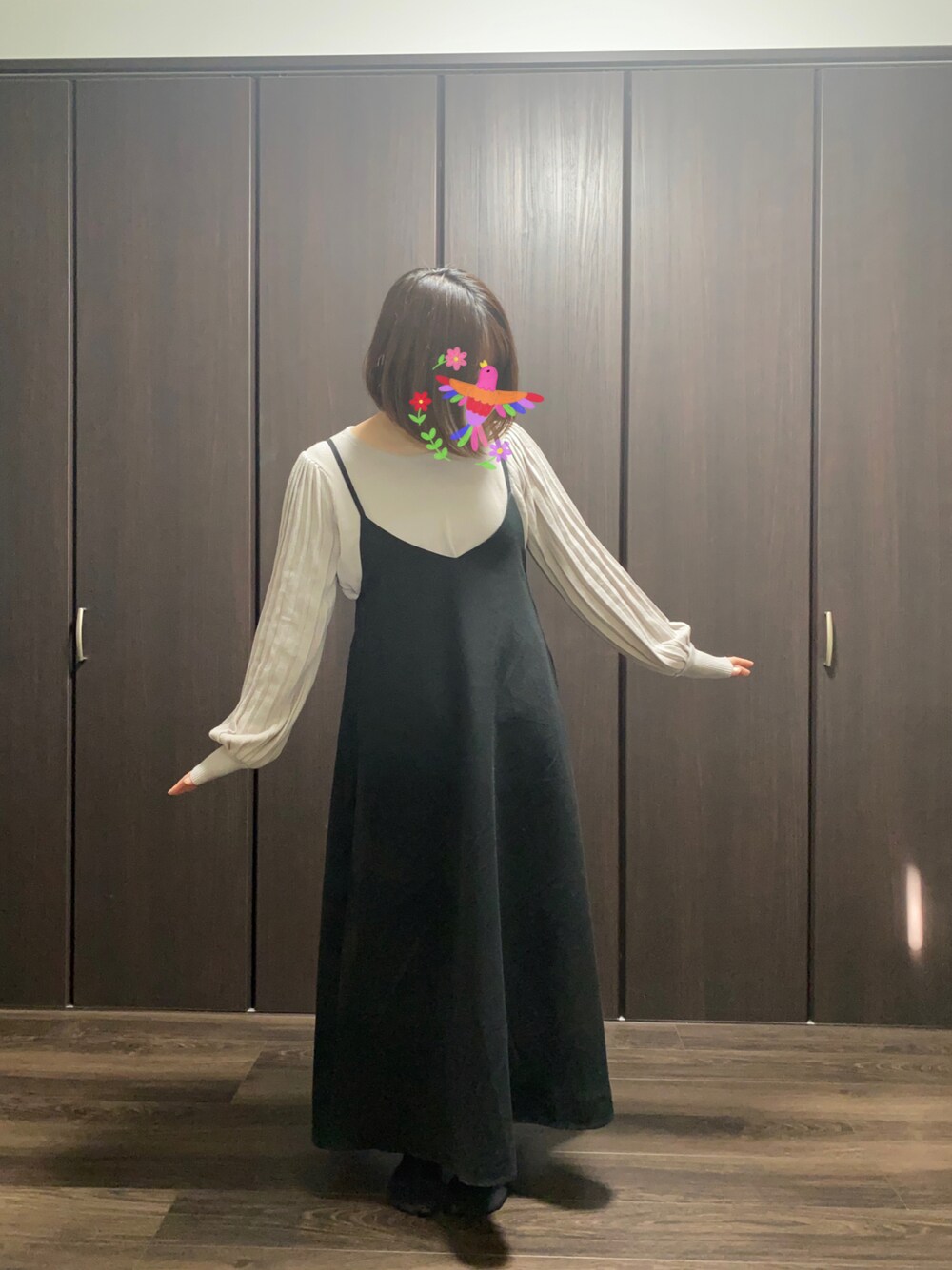 ブラック系のワンピース、ベージュ系のカーディガン/ボレロを着用したレディースの冬コーディネートの1枚目の写真