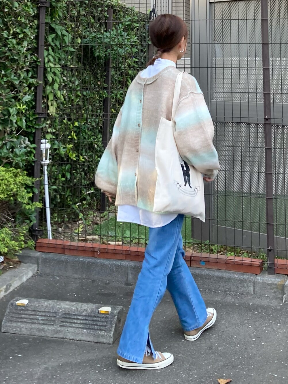 グリーン系のカーディガン/ボレロ、ホワイト系のシャツ/ブラウス、ブルー系のデニムパンツを着用したレディースの秋コーディネートの1枚目の写真