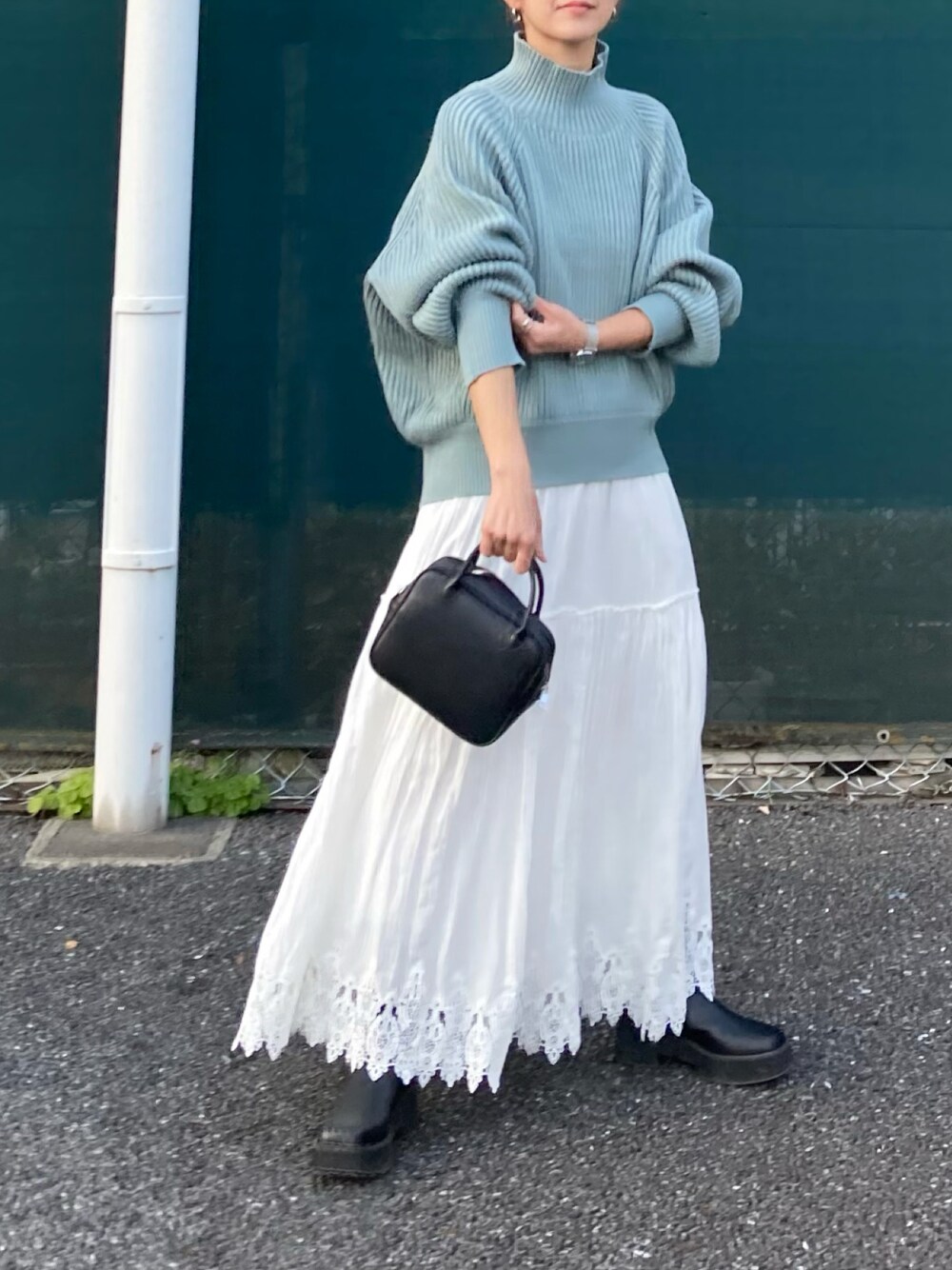 ブルー系のニット/セーター、ブラック系のボストンバッグを着用したレディースの秋コーディネートの1枚目の写真