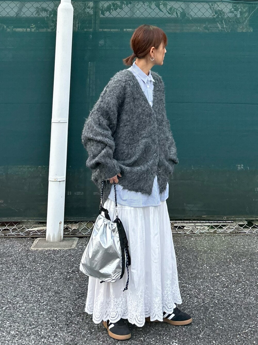 グレー系のカーディガン/ボレロ、ブルー系のシャツ/ブラウス、シルバー系のショルダーバッグを着用したレディースの秋コーディネートの1枚目の写真