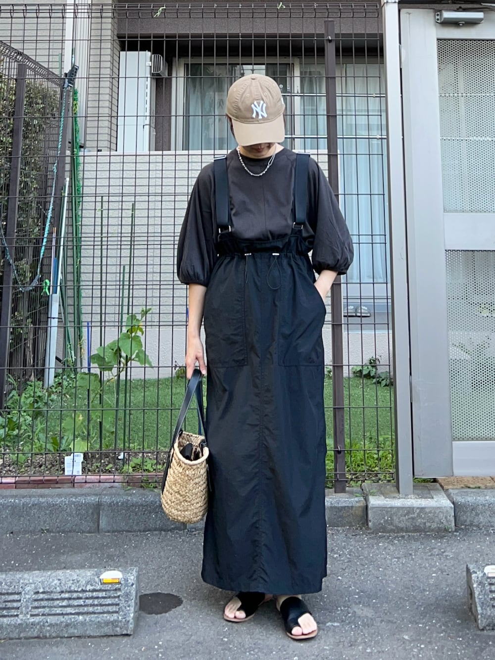 ブラック系のTシャツ/カットソー、ブラック系のジャンパースカート、ブラック系のかごバッグを着用したレディースの夏コーディネートの1枚目の写真