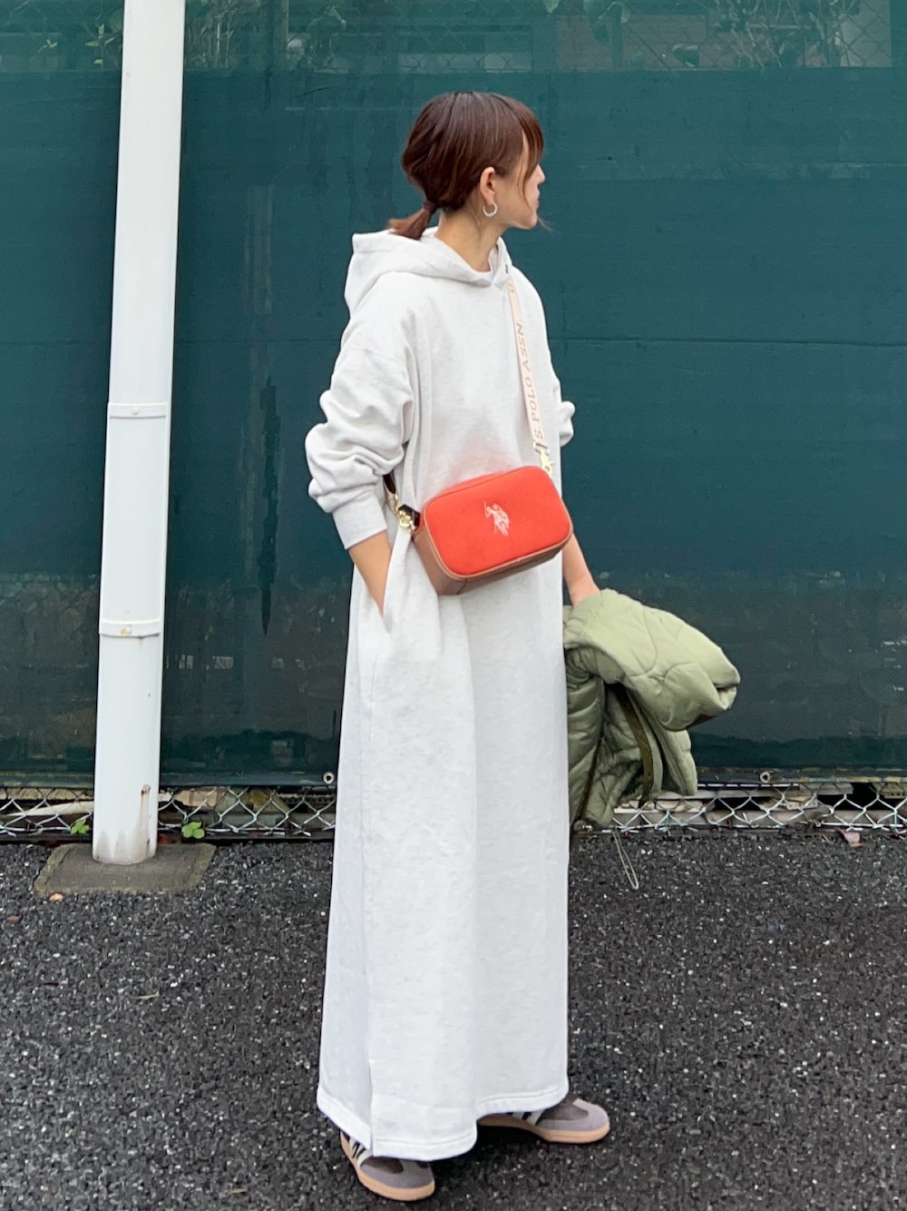 オレンジ系のショルダーバッグ、グレー系のワンピース、グリーン系のノーカラージャケットを着用したレディースの秋コーディネートの1枚目の写真