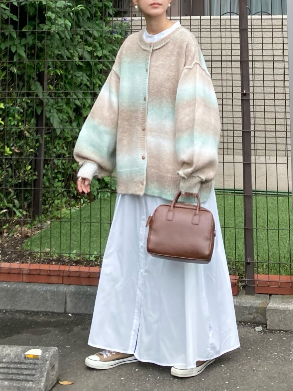 グリーン系のカーディガン/ボレロ、ホワイト系のワンピース、ブラウン系のボストンバッグを着用したレディースの秋コーディネートの1枚目の写真