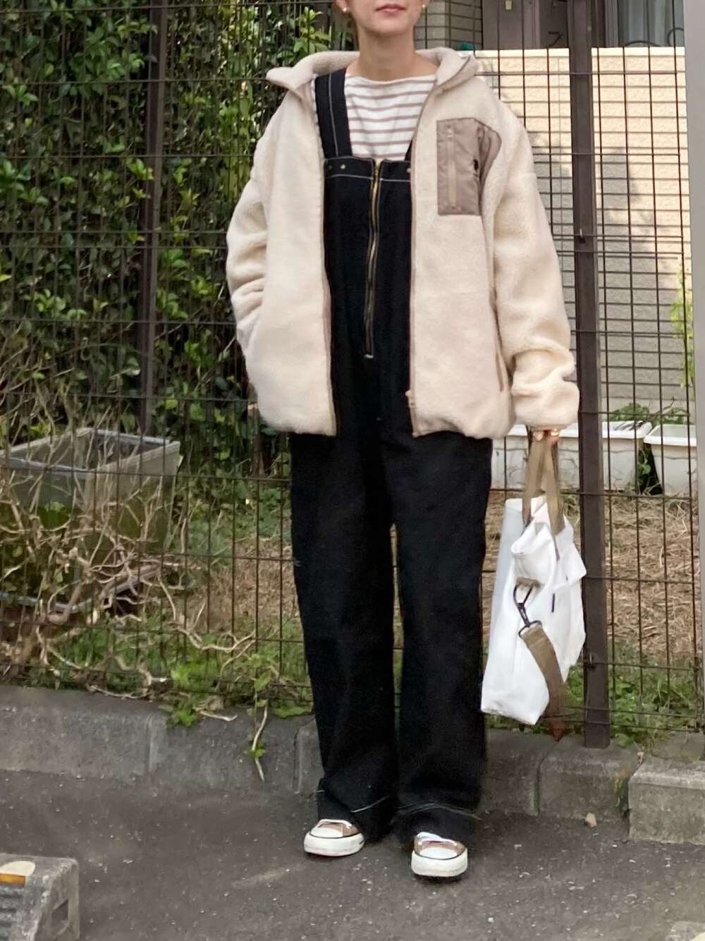 ベージュ系のブルゾン、ベージュ系のTシャツ/カットソー、ブラック系のサロペット/オーバーオールを着用したレディースの秋コーディネートの1枚目の写真
