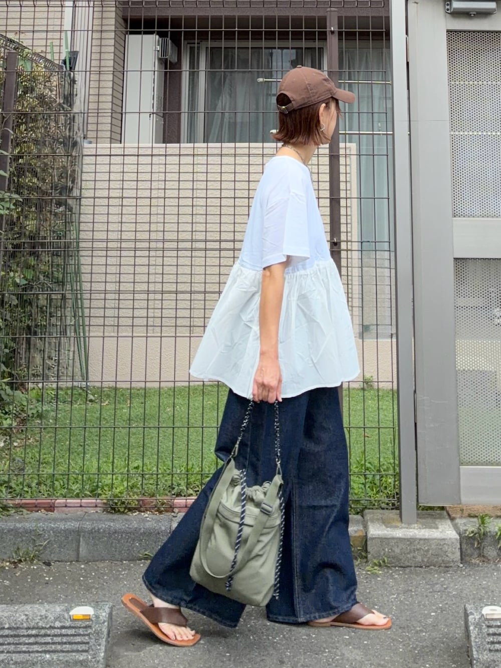 ホワイト系のTシャツ/カットソー、ブルー系のデニムパンツ、グリーン系のショルダーバッグを着用したレディースの夏コーディネートの1枚目の写真