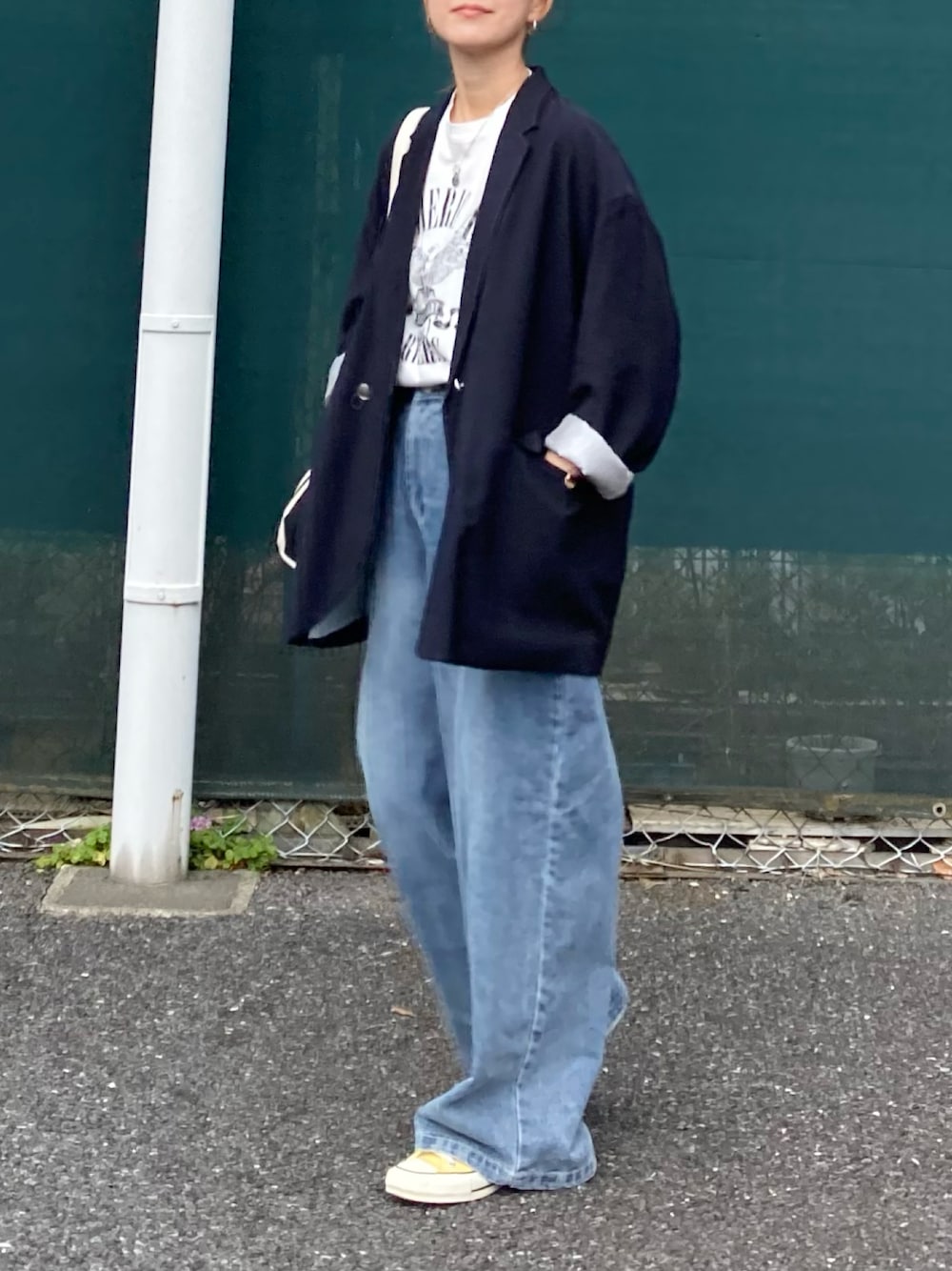 ホワイト系のTシャツ/カットソー、ブルー系のデニムパンツ、ブラック系のトートバッグを着用したレディースの春コーディネートの1枚目の写真