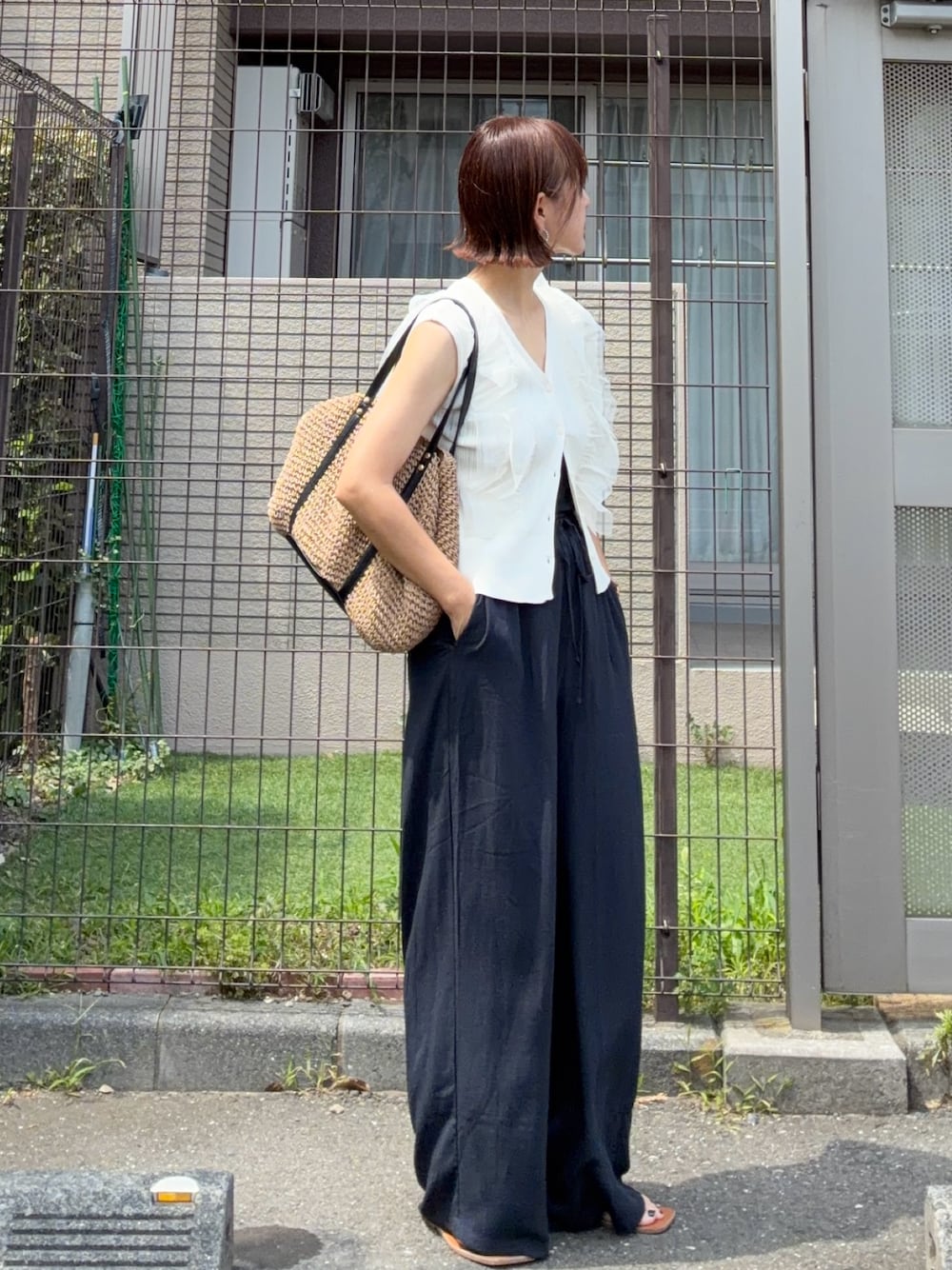 ホワイト系のカーディガン/ボレロ、イエロー系のトートバッグ、ブルー系のスラックスを着用したレディースの夏コーディネートの1枚目の写真