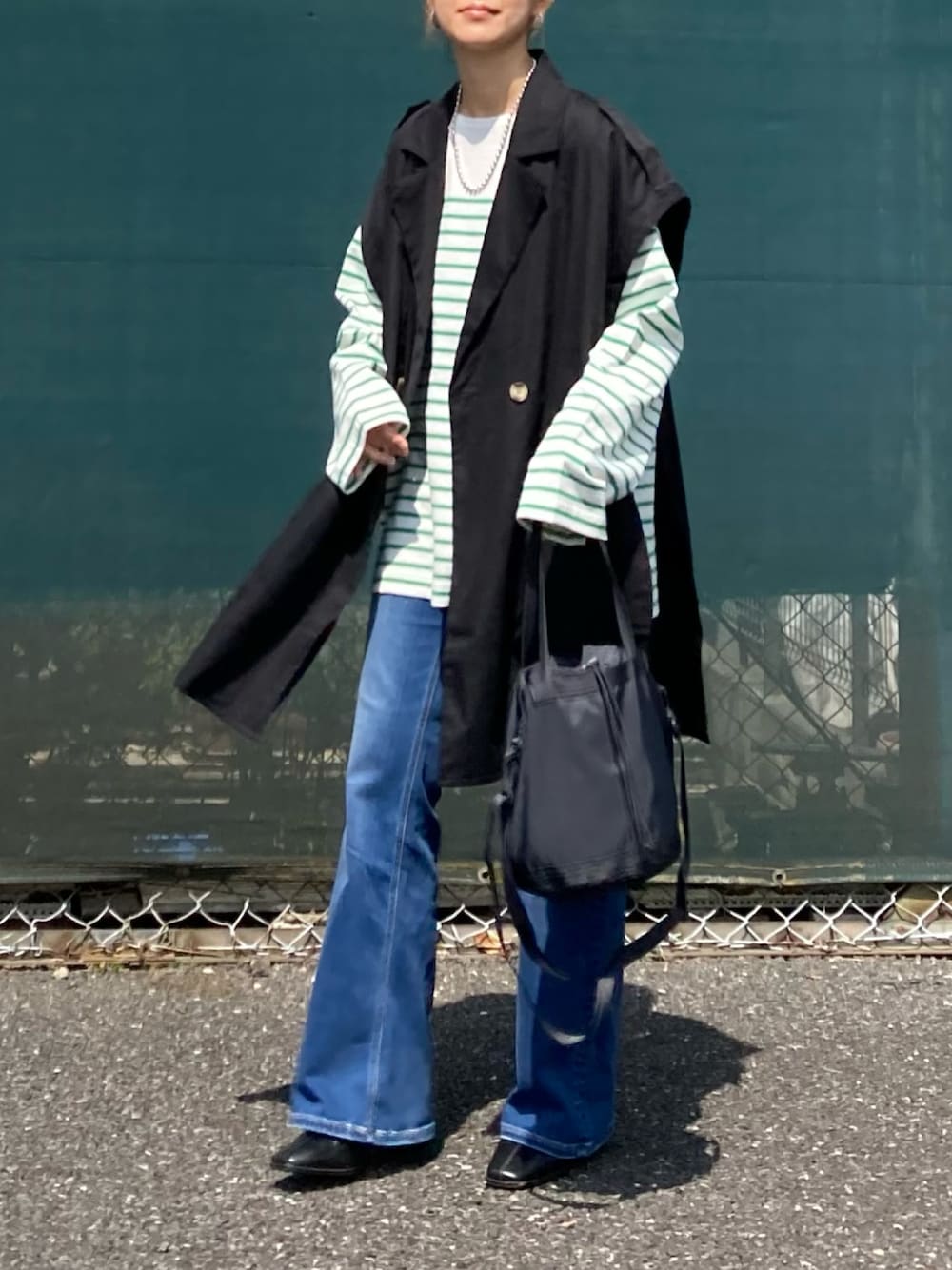 グリーン系のTシャツ/カットソー、ブラック系のその他アウター、ブルー系のデニムパンツを着用したレディースの春コーディネートの1枚目の写真