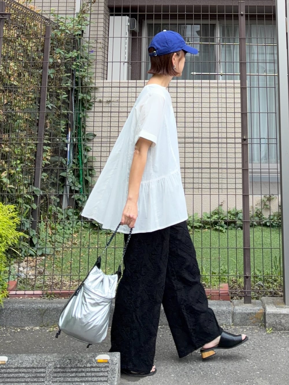 ホワイト系のシャツ/ブラウス、ブラック系のその他パンツ、シルバー系のショルダーバッグを着用したレディースの夏コーディネートの1枚目の写真