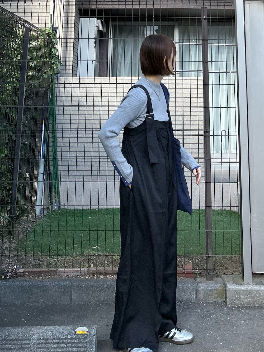 ブラック系のサロペット/オーバーオール、ブルー系のトートバッグ、グレー系のニット/セーターを着用したレディースの冬コーディネートの1枚目の写真