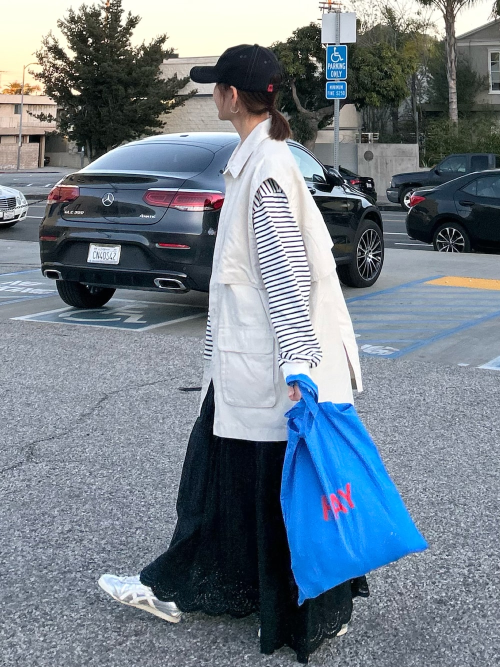 ホワイト系のTシャツ/カットソー、ホワイト系のブルゾン、ブラック系のスカートを着用したレディースの冬コーディネートの1枚目の写真