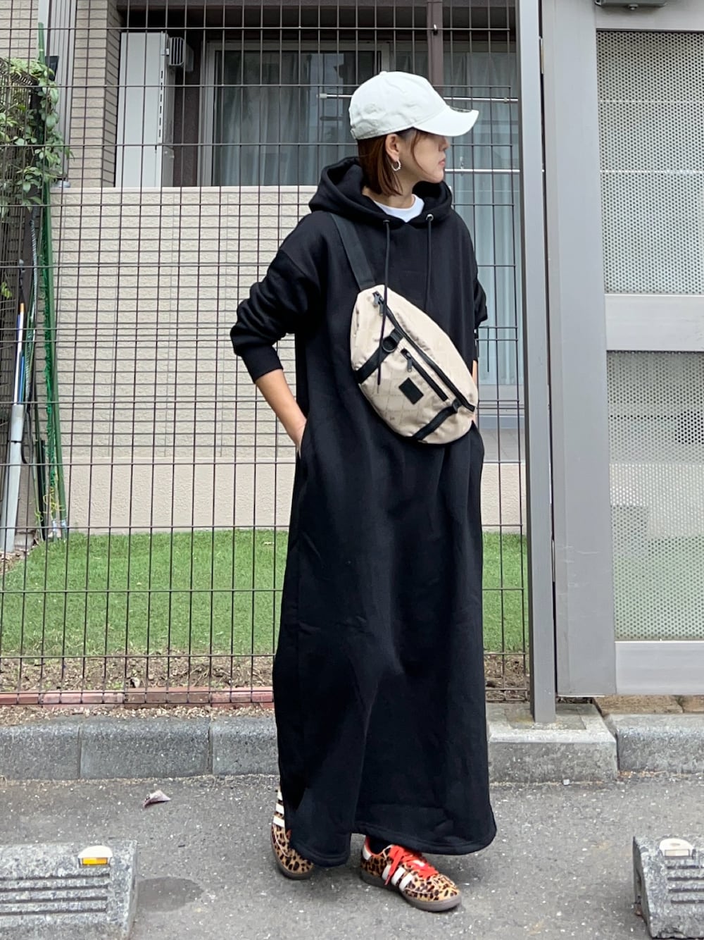 ブラック系のワンピース、その他のショルダーバッグ、ブラック系のスニーカーを着用したレディースの冬コーディネートの1枚目の写真