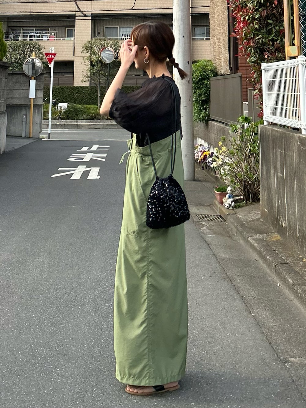 グリーン系のジャンパースカート、ブラック系のシャツ/ブラウス、ブラック系のショルダーバッグを着用したレディースの春コーディネートの1枚目の写真