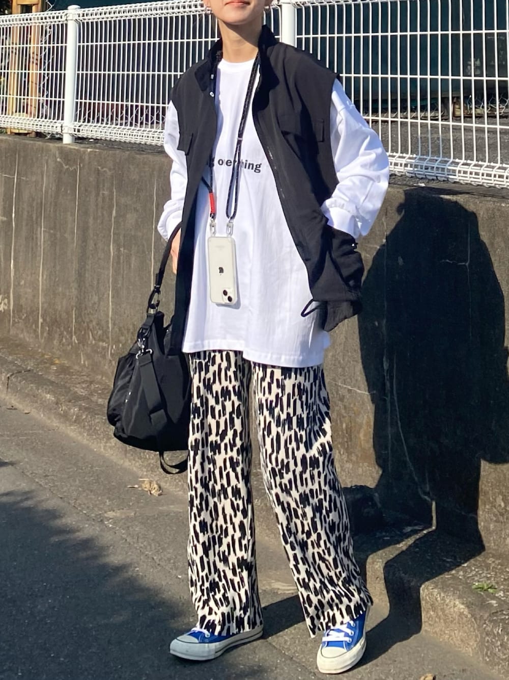 「春のおしゃ見えテクニック、春コーデ、春アウター、春服みてみて、モノトーン、ベスト、ロンT、ロゴT、プリーツパンツ、スニーカー、プチプラ、大人カジュアル、きれいめカジュアル、お出かけコーデ、アウトドアスタイル」｜「recaの【お気に入り数3.2万人突破！】ゆるっとルーズ感！オーバーサイズロゴロンT（Tシャツ/カットソー、ホワイト系）」を使った、ＫＲさん（レディース・159cm）の春コーディネートの1枚目の写真