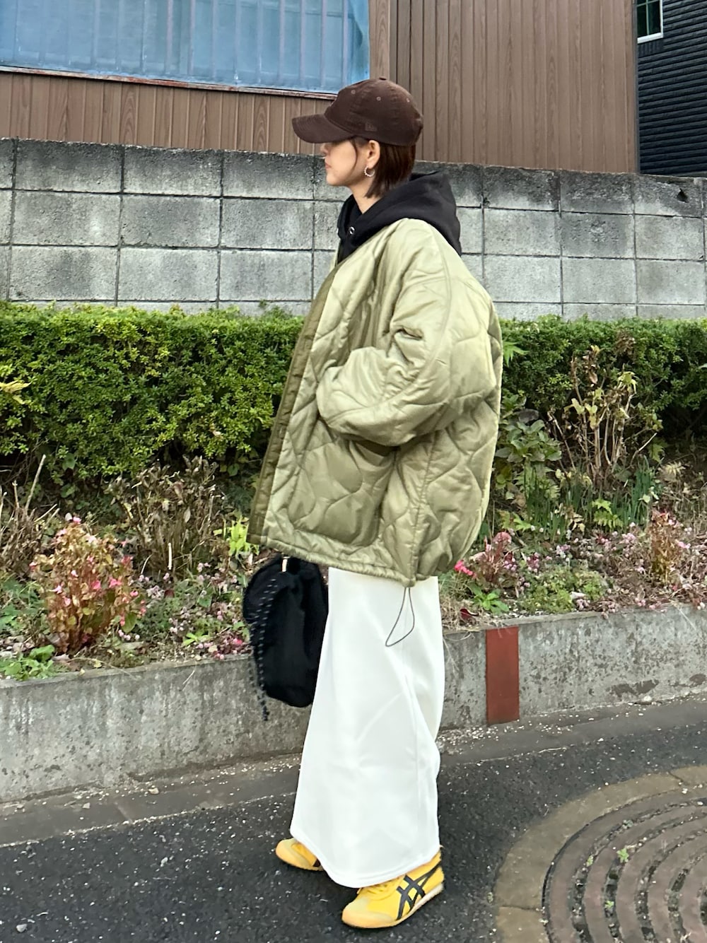 ブラック系のパーカー、ホワイト系のスカート、ブラック系のトートバッグを着用したレディースの冬コーディネートの1枚目の写真