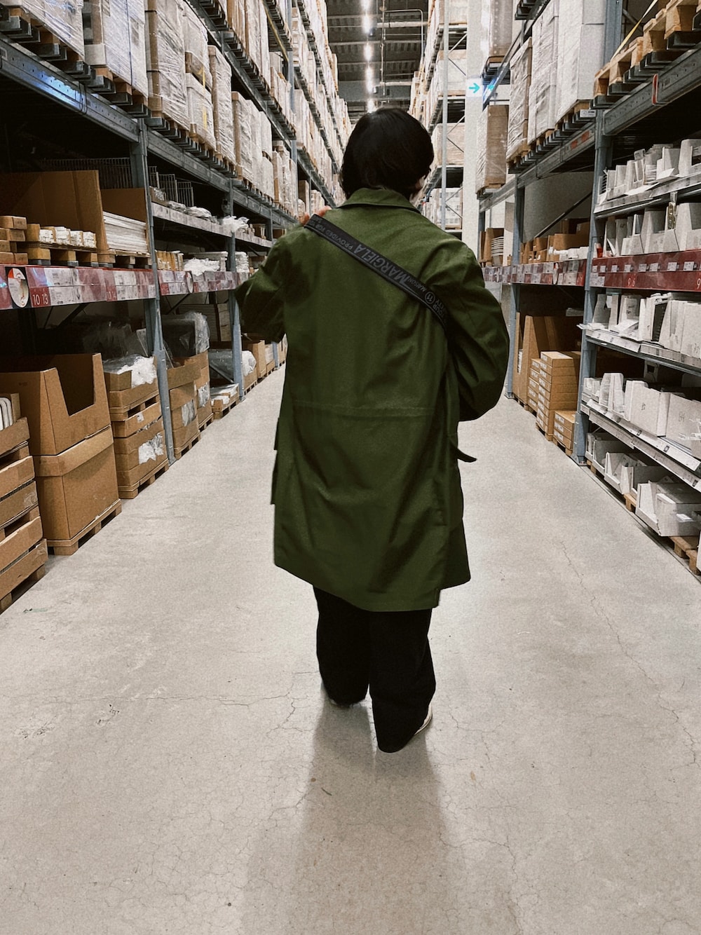 グリーン系のミリタリージャケット、ブラック系のショルダーバッグ、ブラック系のパンツを着用したメンズの春コーディネートの1枚目の写真