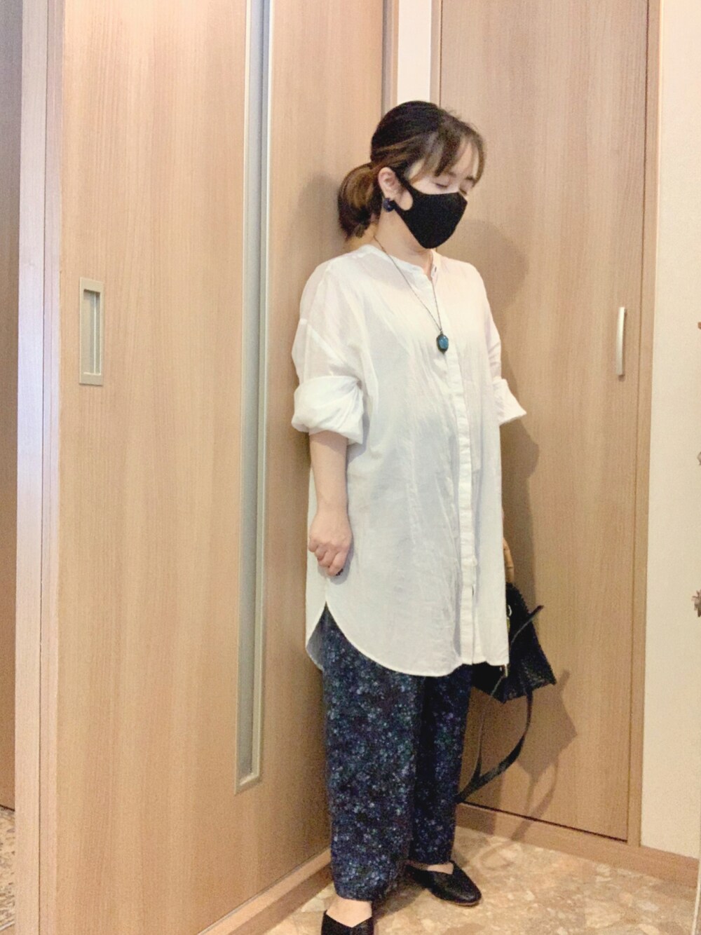 ブラック系のサンダル、ブルー系のパンツ、ブラック系のかごバッグを着用したレディースの秋コーディネートの1枚目の写真