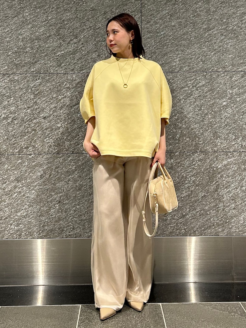 ベージュ系のスラックス、ベージュ系のスラックス、イエロー系のTシャツ/カットソーを着用したレディースの冬コーディネートの1枚目の写真