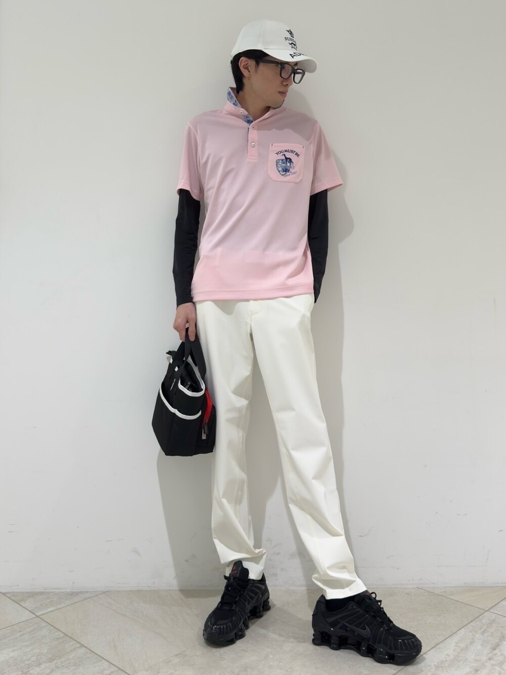 ピンク系のポロシャツ、ブラック系のTシャツ/カットソー、ホワイト系のその他パンツを着用したメンズの夏コーディネートの1枚目の写真