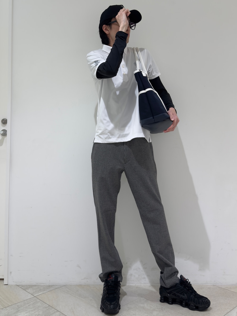 ホワイト系のポロシャツ、ブラック系のTシャツ/カットソー、グレー系のその他パンツを着用したメンズの秋コーディネートの1枚目の写真