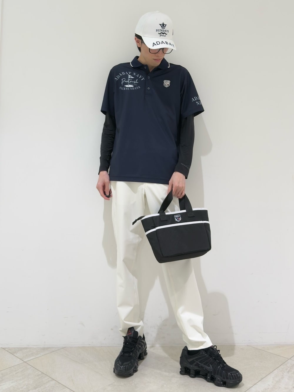 ブルー系のポロシャツ、ブラック系のTシャツ/カットソー、ホワイト系のその他パンツを着用したメンズの夏コーディネートの1枚目の写真