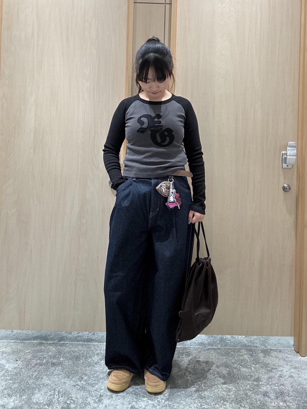 ブラウン系のバックパック/リュック、ブラック系のTシャツ/カットソー、ブラウン系のベルトを着用したレディースの夏コーディネートの1枚目の写真