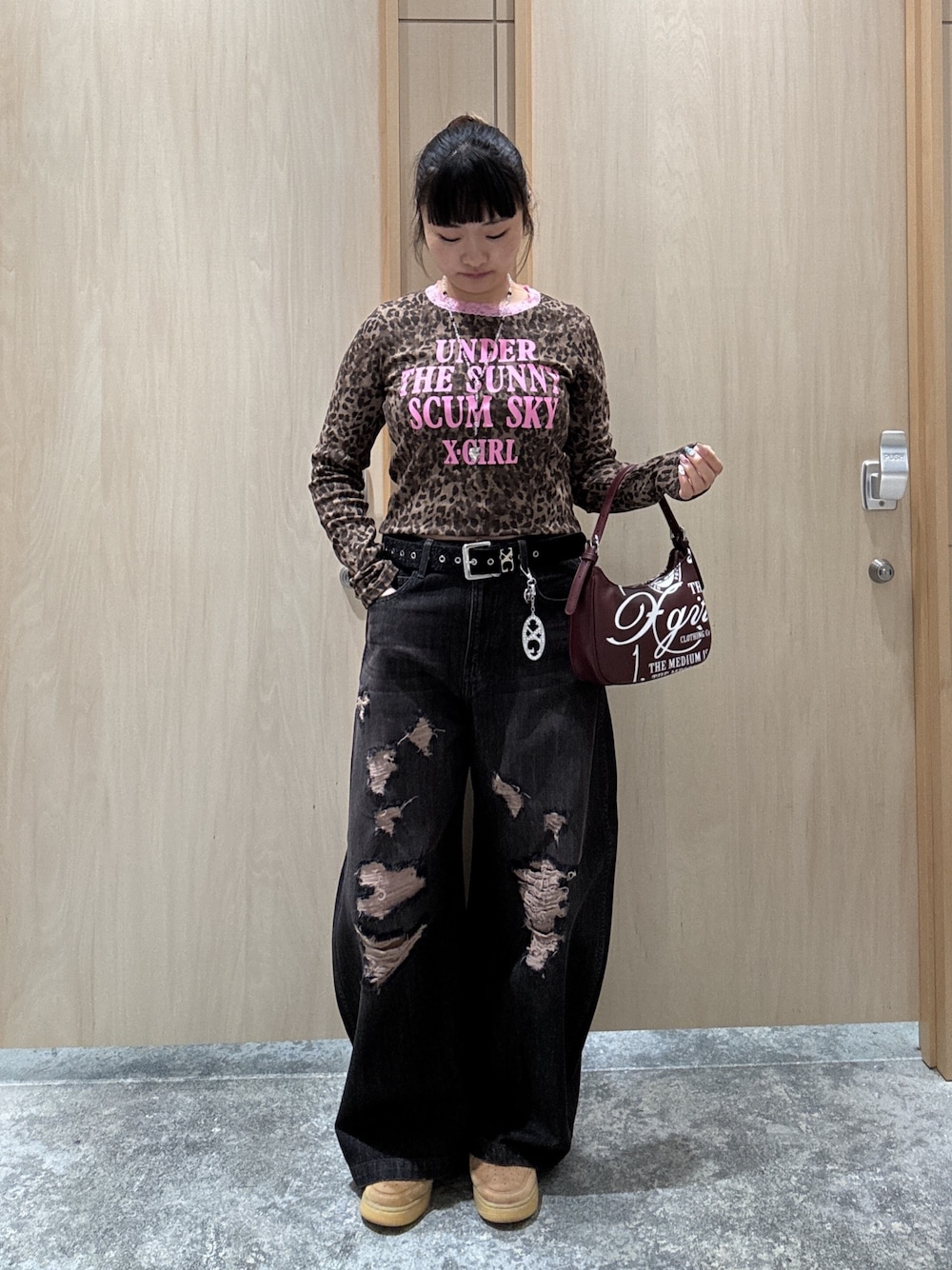 ブラック系のデニムパンツ、レッド系のハンドバッグ、ベージュ系のTシャツ/カットソーを着用したレディースの秋コーディネートの1枚目の写真