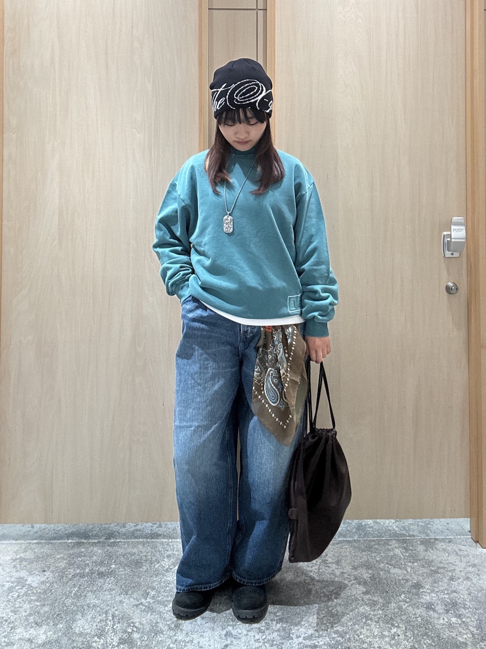 グリーン系のスウェット、ホワイト系のTシャツ/カットソー、ブルー系のデニムパンツを着用したレディースの秋コーディネートの1枚目の写真