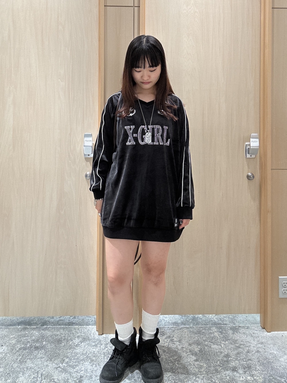 ブラック系のワンピース、ブラウン系のバックパック/リュック、ブルー系のデニムパンツを着用したレディースの秋コーディネートの1枚目の写真