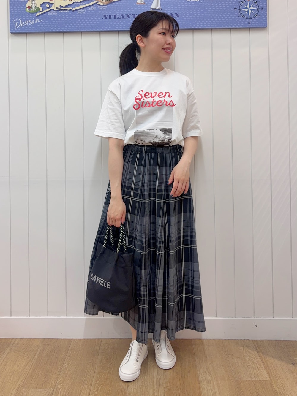 ホワイト系のTシャツ/カットソー、グリーン系のスカート、ホワイト系のスニーカーを着用したレディースの春コーディネートの1枚目の写真