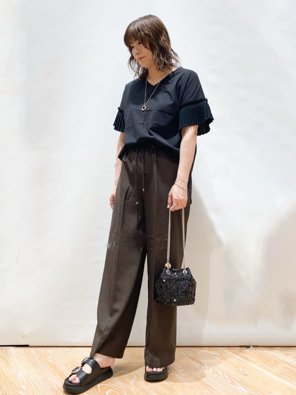 ブラック系のTシャツ/カットソー、ブラウン系のその他パンツ、ブラック系のショルダーバッグを着用したレディースの夏コーディネートの1枚目の写真