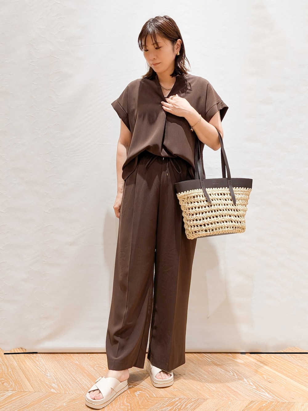 ブラウン系のシャツ/ブラウス、ブラウン系のその他パンツ、ブラウン系のトートバッグを着用したレディースの夏コーディネートの1枚目の写真