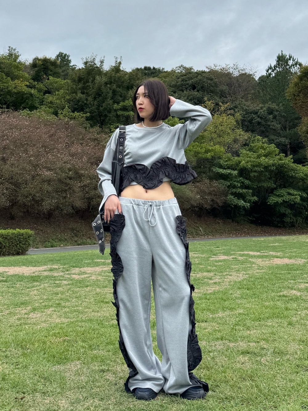 グレー系のスウェット、グレー系のスウェットパンツ、ブルー系のローファーを着用したレディースの秋コーディネートの1枚目の写真