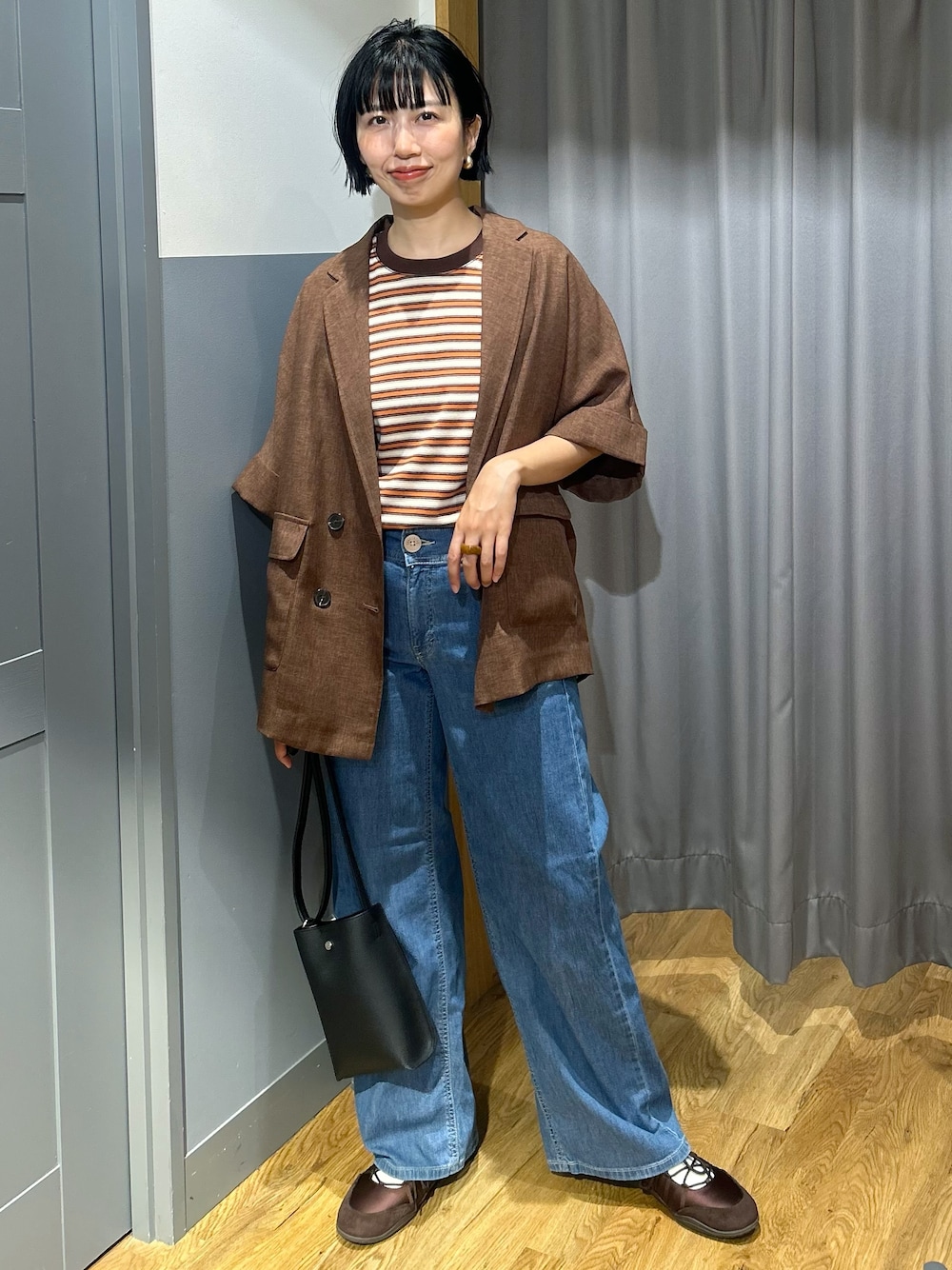 オレンジ系のTシャツ/カットソー、ブラウン系のテーラードジャケット、ブルー系のデニムパンツを着用したレディースの夏コーディネートの1枚目の写真