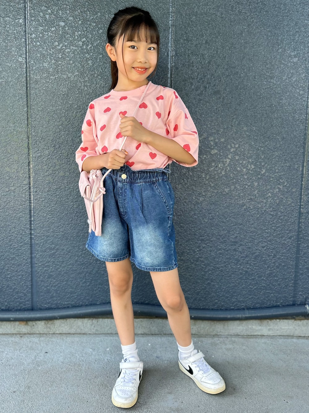 ピンク系のTシャツ/カットソー、ブルー系のその他パンツ、ピンク系のショルダーバッグを着用したキッズの夏コーディネートの1枚目の写真
