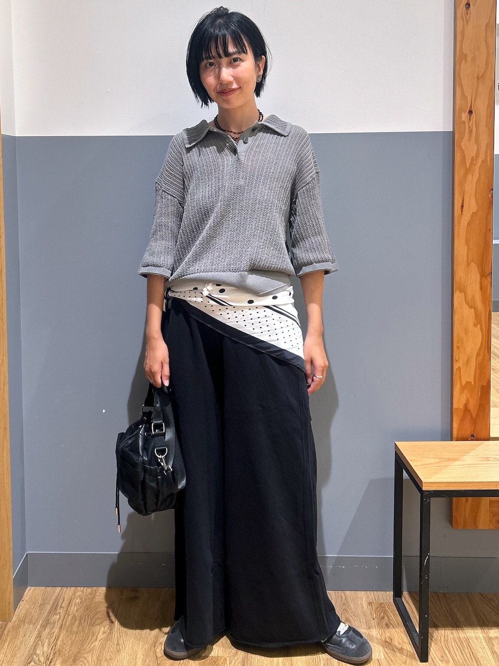 グレー系のニット/セーター、ブラック系のその他パンツ、ブラック系のショルダーバッグを着用したレディースの秋コーディネートの1枚目の写真
