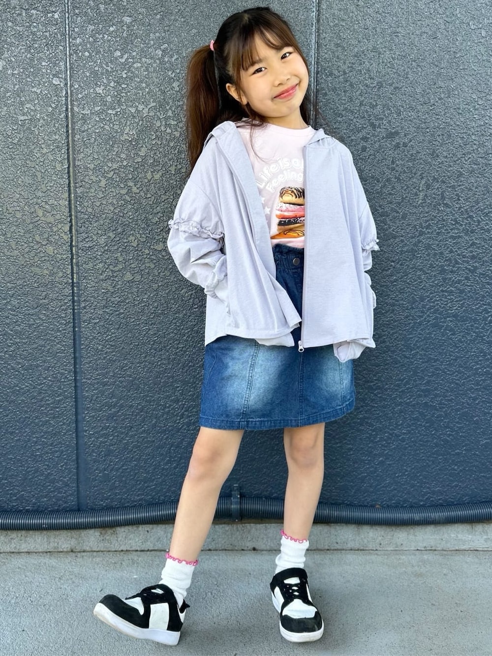 ピンク系のTシャツ/カットソー、ブルー系のデニムスカート、パープル系のパーカーを着用したキッズの春コーディネートの1枚目の写真